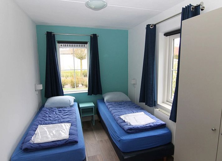 Das Ferienhaus F 778 in De Cocksdorp, Texel, bietet einen ruhigen Aussenbereich mit gruener Umgebung und einer grossen Terrasse zum Entspannen auf den Watteninseln.