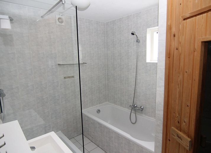 Das Ferienhaus F 778 in De Cocksdorp, Texel, bietet einen ruhigen Aussenbereich mit gruener Umgebung und einer grossen Terrasse zum Entspannen auf den Watteninseln.