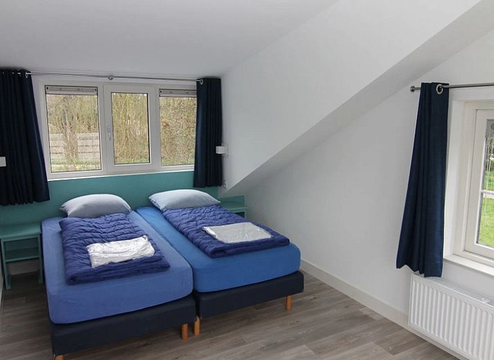 Das Ferienhaus F 778 in De Cocksdorp, Texel, bietet einen ruhigen Aussenbereich mit gruener Umgebung und einer grossen Terrasse zum Entspannen auf den Watteninseln.