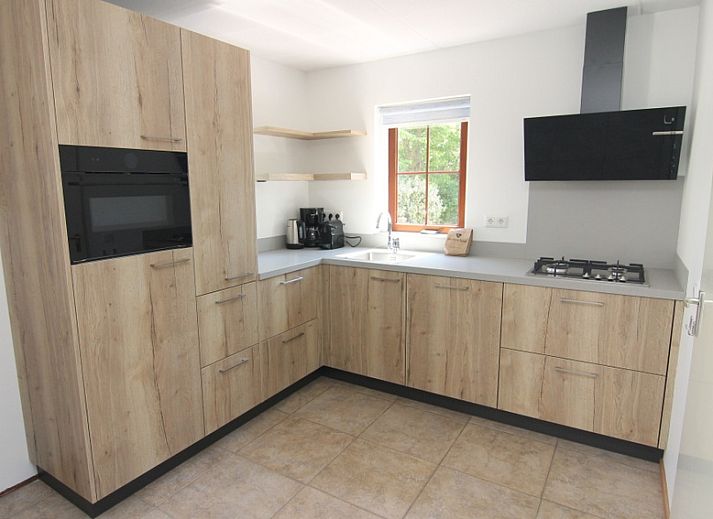 Vakantiehuis E 413 in De Cocksdorp, Texel, biedt een charmante buitenkant met een zonnig terras op de Waddeneilanden.