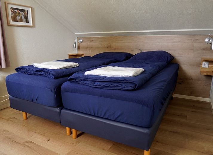 Vakantiehuis E 413 in De Cocksdorp, Texel, biedt een charmante buitenkant met een zonnig terras op de Waddeneilanden.