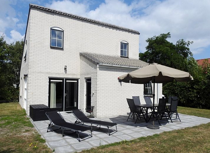 Geniet van de zon op het terras van Vakantiehuis E 614 in De Cocksdorp, Texel, met comfortabele ligstoelen en een parasol voor ontspanning.