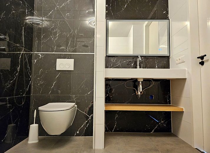 Enjoy the sun on the terrace of Holiday home E 525 in De Cocksdorp, Texel, with comfortable seating and green surroundings.