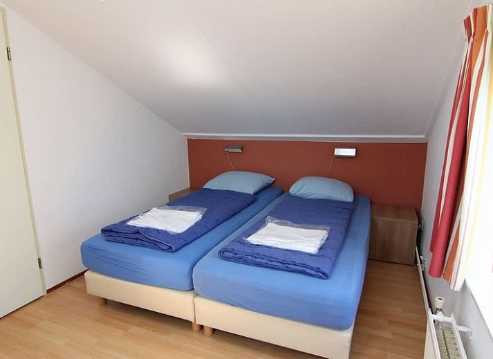 Das Ferienhaus F 713 in De Cocksdorp, Texel, bietet einen ruhigen Aussenbereich mit gruener Umgebung und einladender Architektur.