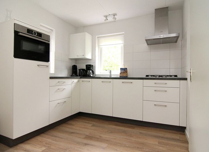 Vakantiehuis E 397 in De Cocksdorp, Texel, biedt een charmante buitenaanblik met groene omgeving voor een ontspannen eilandverblijf.