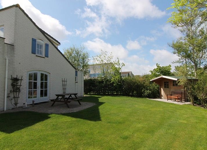 Vakantiehuis F 602 in De Cocksdorp, Texel, omgeven door groene natuur en een uitnodigend pad naar de voordeur van deze charmante vakantiewoning.