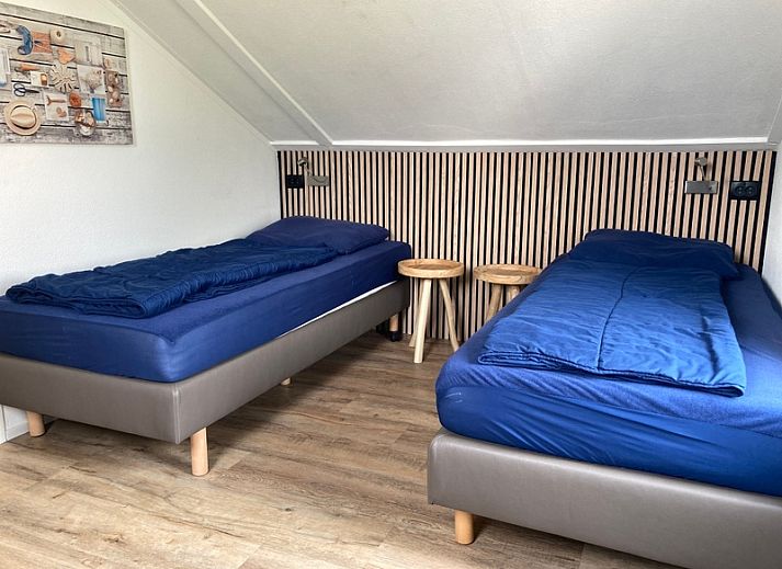 Gezellige terras van Vakantiehuis E 501 in De Cocksdorp, Texel met moderne zitruimte en groene tuin voor ultiem buitenplezier.