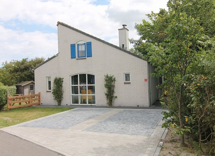Vakantiehuis E 421 in De Cocksdorp, Texel, biedt een uitnodigende entree met een ruime oprit en groene omgeving op de Waddeneilanden.
