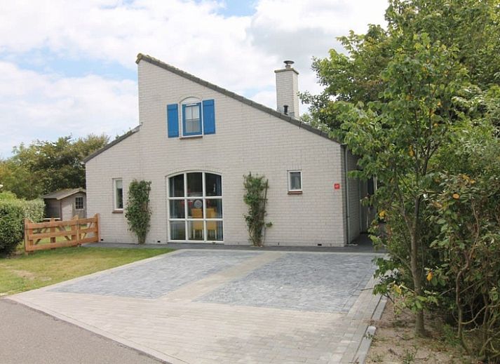 Vakantiehuis E 421 in De Cocksdorp, Texel, biedt een uitnodigende entree met een ruime oprit en groene omgeving op de Waddeneilanden.