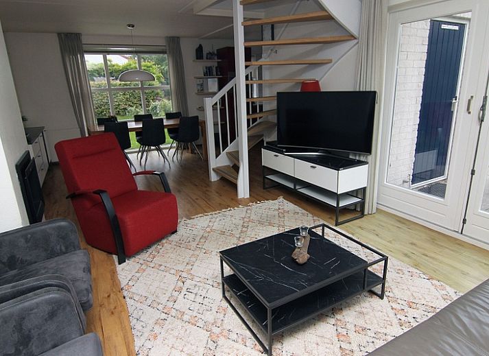 Das Ferienhaus E 511 in De Cocksdorp auf Texel bietet einen schoenen Aussenbereich mit gruener Umgebung und einer einladenden Terrasse.