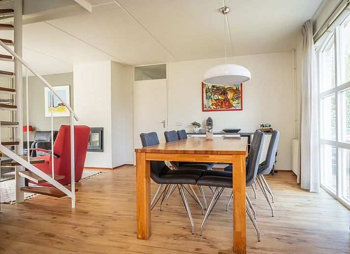 Das Ferienhaus E 511 in De Cocksdorp auf Texel bietet einen schoenen Aussenbereich mit gruener Umgebung und einer einladenden Terrasse.