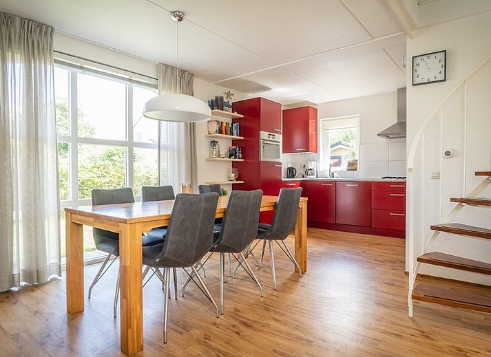 Das Ferienhaus E 511 in De Cocksdorp auf Texel bietet einen schoenen Aussenbereich mit gruener Umgebung und einer einladenden Terrasse.
