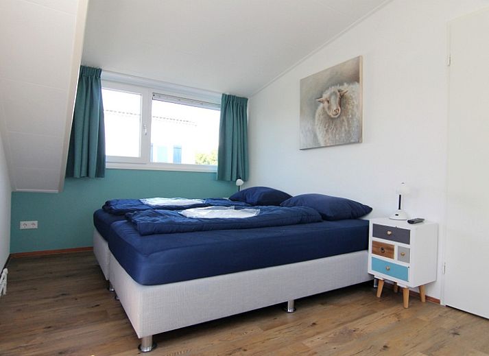 Das Ferienhaus E 511 in De Cocksdorp auf Texel bietet einen schoenen Aussenbereich mit gruener Umgebung und einer einladenden Terrasse.