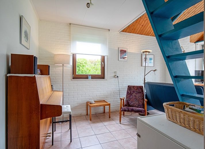 Gezellige woonkamer van Vakantiehuis Slufterhoek 110 in De Cocksdorp, Texel, met comfortabele zitplaatsen en uitzicht op de tuin.