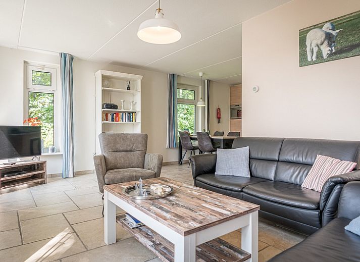 Bungalow Klein Axel, charmant vakantiehuis met terras in De Cocksdorp, Texel, omgeven door groene natuur.