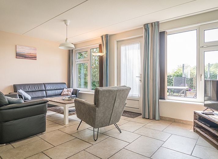 Bungalow Klein Axel, charmant vakantiehuis met terras in De Cocksdorp, Texel, omgeven door groene natuur.