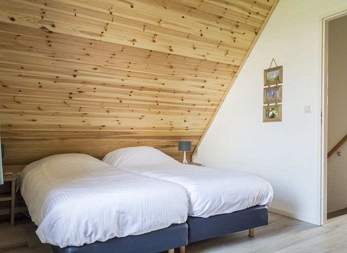 Bungalow Klein Axel in De Cocksdorp, Texel, te midden van bloeiende bloemenvelden, ideale vakantiebestemming.