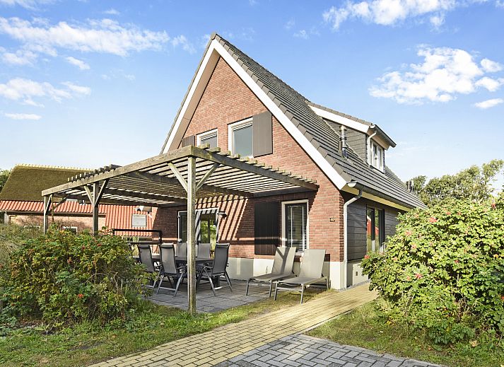 Bright living room with dining area in Sluftervallei bungalow, De Cocksdorp, Texel. Ideal for family gatherings.