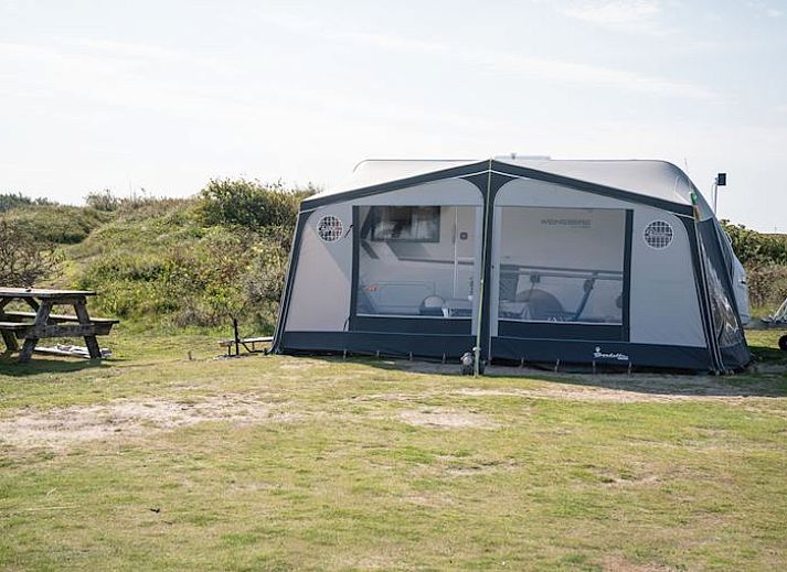 Kind speelt op gras bij Sluftervallei Comfort campingplaats C3 in De Cocksdorp, Texel.