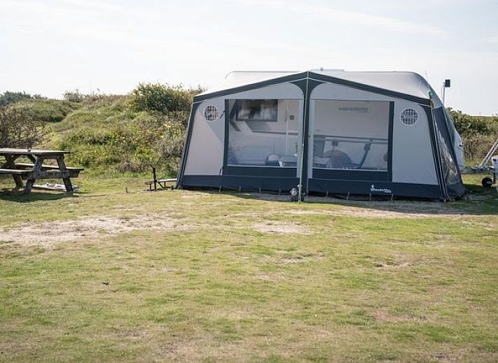 Kind speelt op gras bij Sluftervallei Comfort campingplaats C3 in De Cocksdorp, Texel.