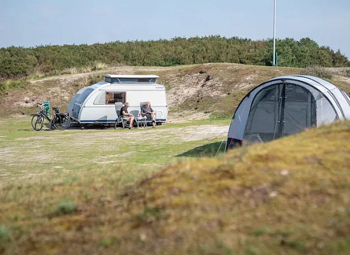 Gezin ontspant buiten caravan op Sluftervallei Comfort campingplaats C3, De Cocksdorp, Texel.