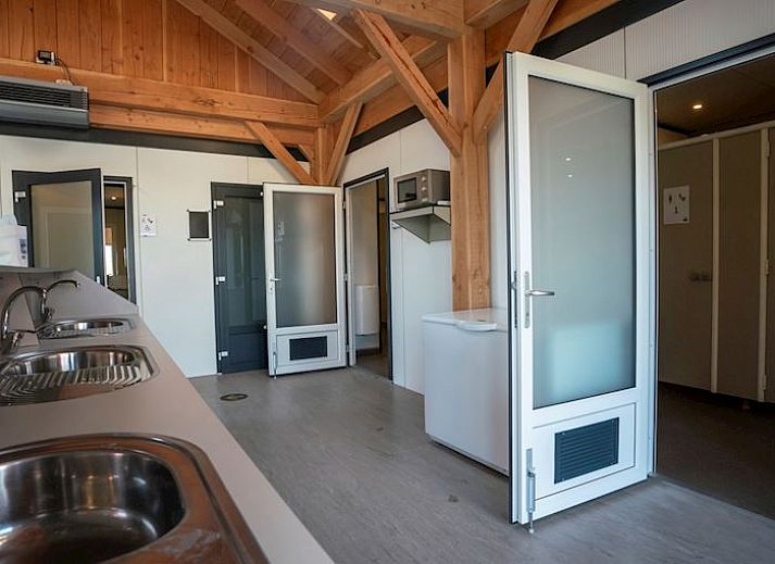 Gezin ontspant buiten caravan op Sluftervallei Comfort campingplaats C3, De Cocksdorp, Texel.