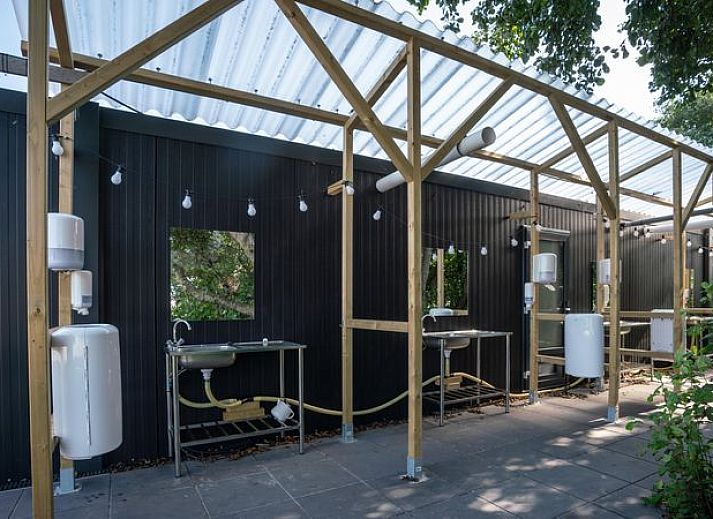 Gezin ontspant buiten caravan op Sluftervallei Comfort campingplaats C3, De Cocksdorp, Texel.
