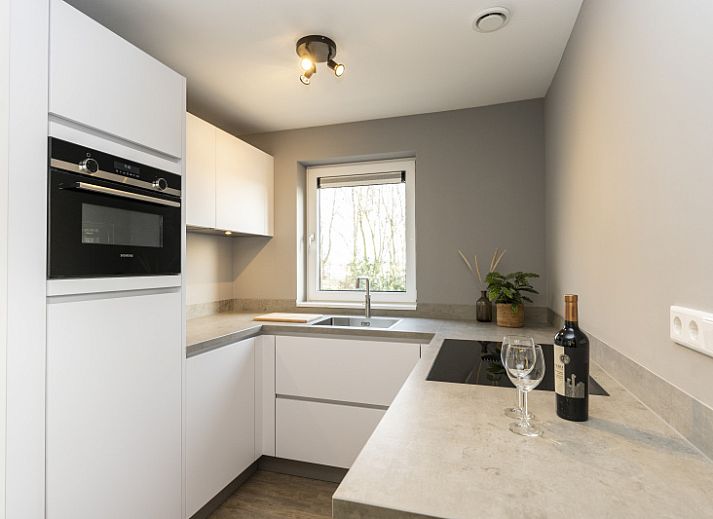 Stijlvolle woonkamer in Duinoord Texel vakantiehuis, De Cocksdorp, met comfortabele leren banken.