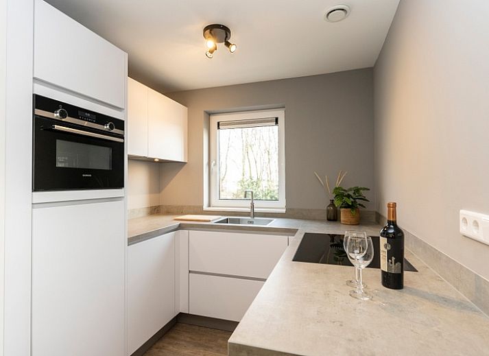 Stijlvolle woonkamer in Duinoord Texel vakantiehuis, De Cocksdorp, met comfortabele leren banken.