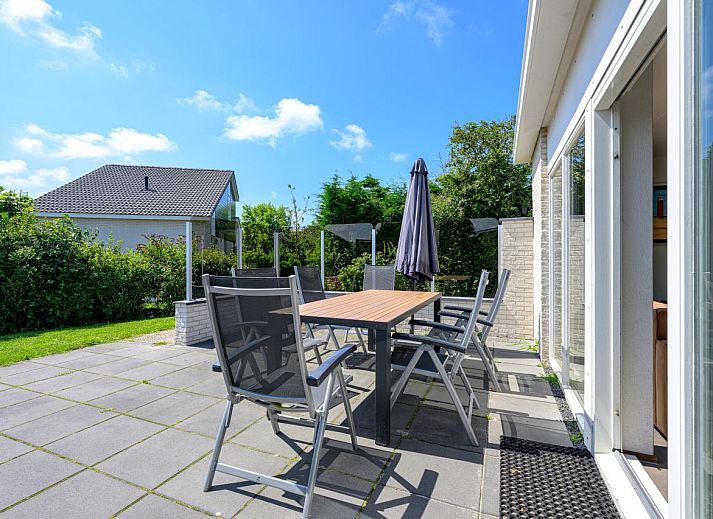 Gemtliches Wohnzimmer in freistehendem Haus in De Koog, Texel, mit moderner Einrichtung und Blick auf Terrasse und Garten.