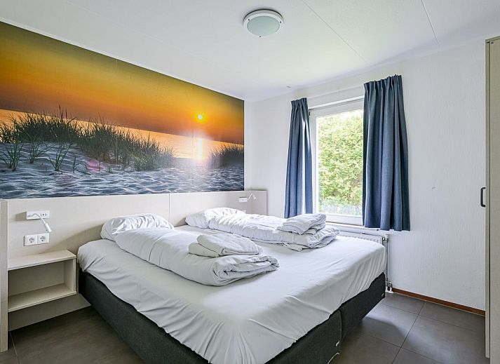 Gemtliches Wohnzimmer in freistehendem Haus in De Koog, Texel, mit moderner Einrichtung und Blick auf Terrasse und Garten.