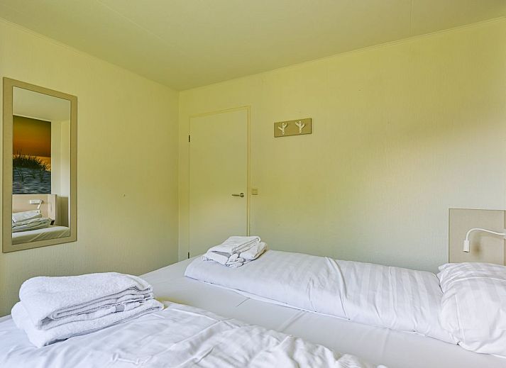 Gemtliches Wohnzimmer in freistehendem Haus in De Koog, Texel, mit moderner Einrichtung und Blick auf Terrasse und Garten.