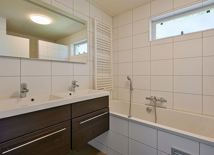 Gemtliches Wohnzimmer in freistehendem Haus in De Koog, Texel, mit moderner Einrichtung und Blick auf Terrasse und Garten.