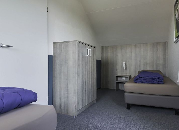 Gerumiges Wohnzimmer eines freistehenden Hauses in De Koog, Texel, mit moderner Einrichtung und viel natrlichem Licht durch die groen Fenster.