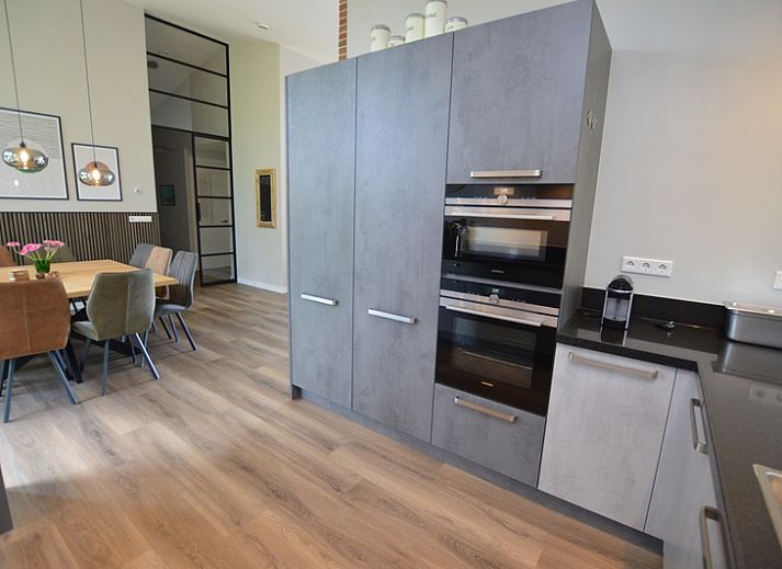 Stijlvolle woonkamer van Orchismient 49 in De Koog, Texel met uitzicht op de natuur.