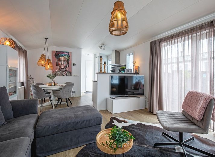 Chalet Bregkoog 52 in De Koog, Texel, met zonnige veranda en kleurrijke zonnebloemen bij Chaletpark Bregkoog.