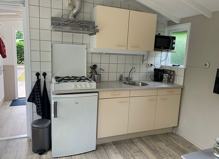 Geniet van het terras bij vakantiehuis Hoog Koog 12 in Bungalowpark Hoog Koog, De Koog, Texel, omringd door groene natuur.