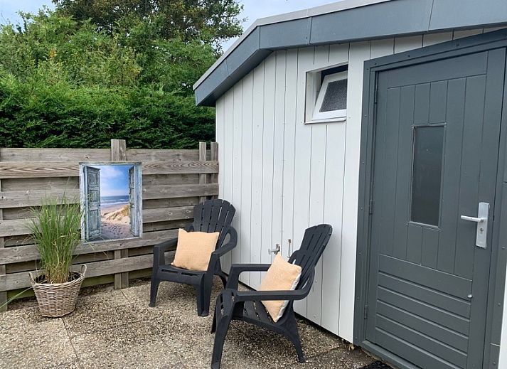 Geniet van het terras bij vakantiehuis Hoog Koog 12 in Bungalowpark Hoog Koog, De Koog, Texel, omringd door groene natuur.