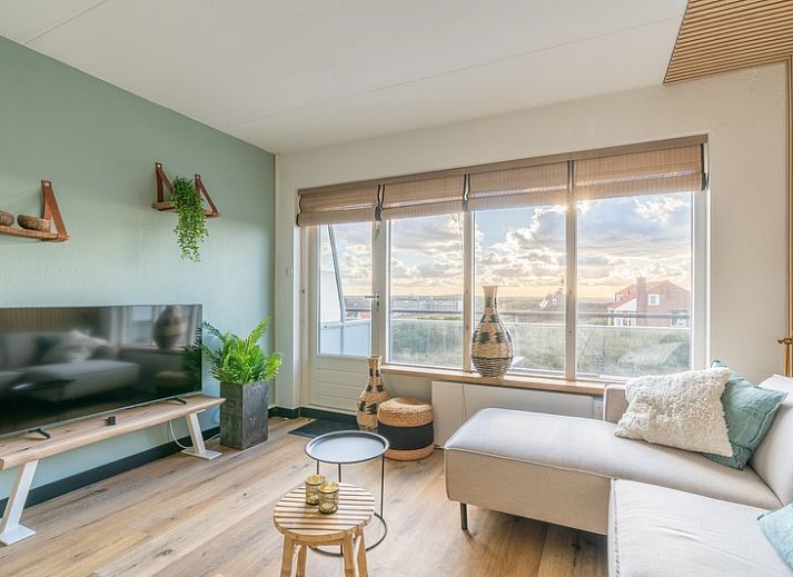 Appartement Juliana 140 Eiland en Zeezicht in De Koog, Texel biedt een sfeervolle woonkamer met uitzicht op de duinen.