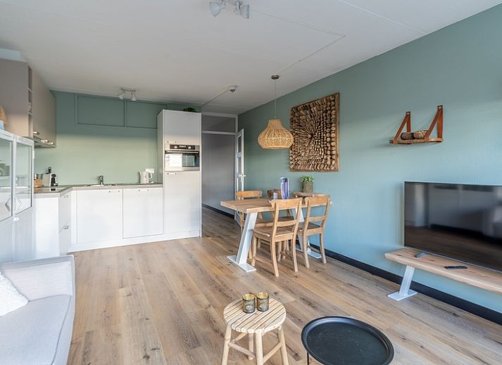 Appartement Juliana 140 Eiland en Zeezicht in De Koog, Texel biedt een sfeervolle woonkamer met uitzicht op de duinen.