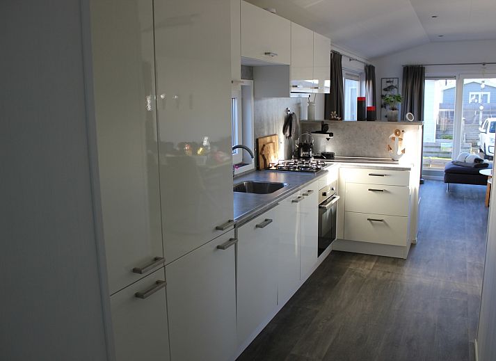 Zijaanzicht van Chalet Bregkoog 232, gelegen in De Koog, Texel, met zonnig terras.