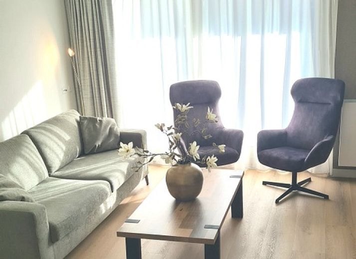 Gezellige woonkamer van Motel Texel Appartement (1N) in De Koog, Texel, met comfortabele bank en sfeervolle decoraties.