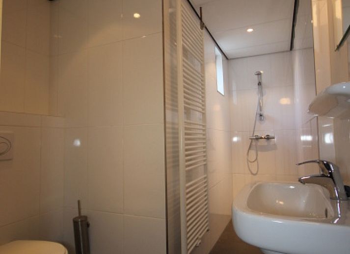 Cozy living room of Landhuis Landleven No. 81 in De Koog, Texel with comfortable sitting area and wood stove.