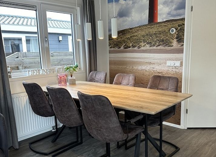 Chalet Bregkoog 232 in De Koog, Texel, met houten omheining en grote ramen, ideaal vakantiehuis op de Waddeneilanden.