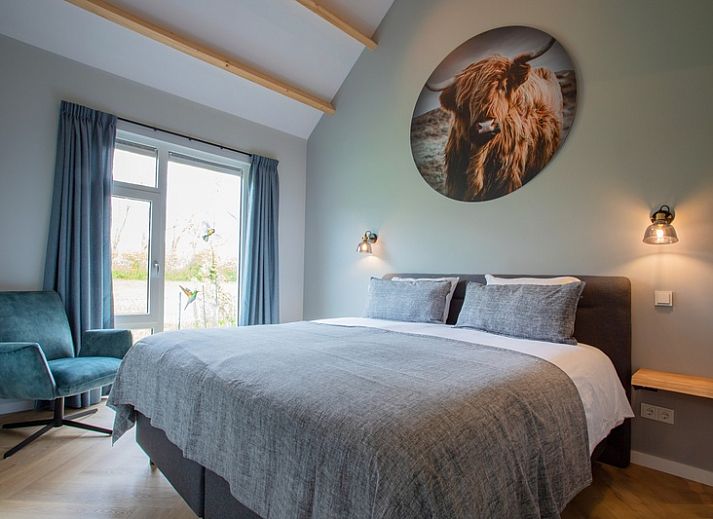 Stijlvolle woonkamer in De Houtsnip vakantiehuis, De Koog, Texel met hoge plafonds en comfortabele zithoek.