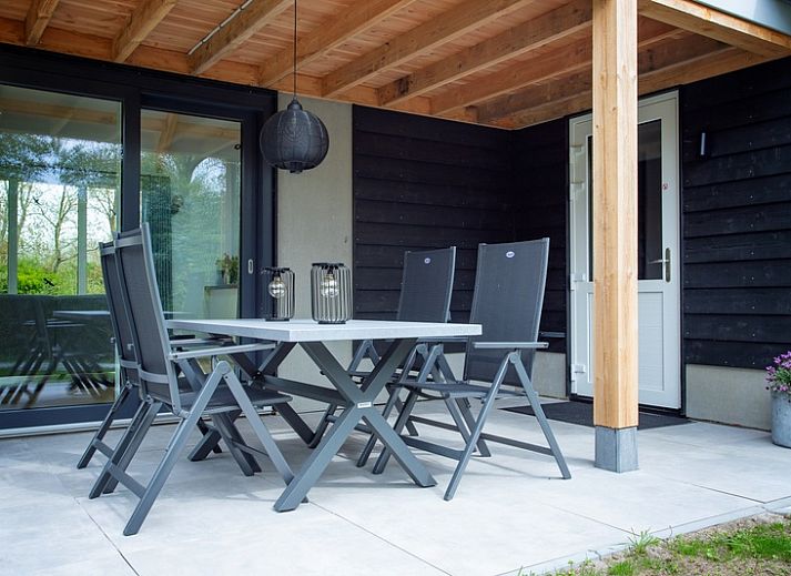 Stijlvolle woonkamer in De Houtsnip vakantiehuis, De Koog, Texel met hoge plafonds en comfortabele zithoek.