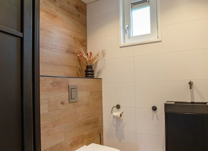 Stijlvolle woonkamer in De Houtsnip vakantiehuis, De Koog, Texel met hoge plafonds en comfortabele zithoek.