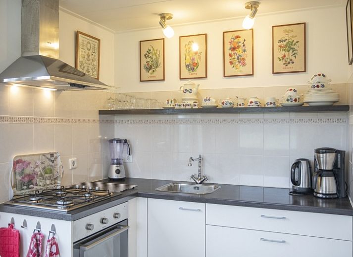 Charmante entree van vakantiehuis 't Paviljoen in De Koog, Texel met bloemen en groene omgeving.