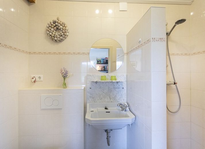 Charmante entree van vakantiehuis 't Paviljoen in De Koog, Texel met bloemen en groene omgeving.