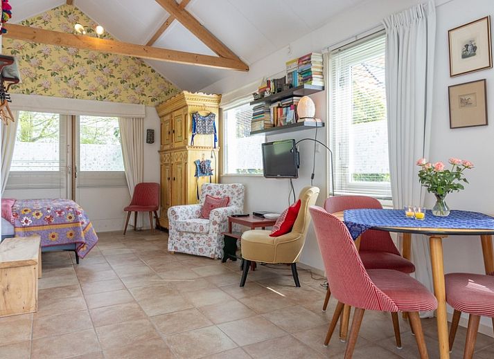 Charmante entree van vakantiehuis 't Paviljoen in De Koog, Texel met bloemen en groene omgeving.